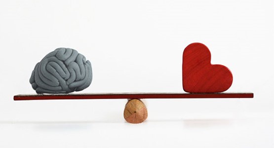 imagen de un cerebro y un corazón en una balanza